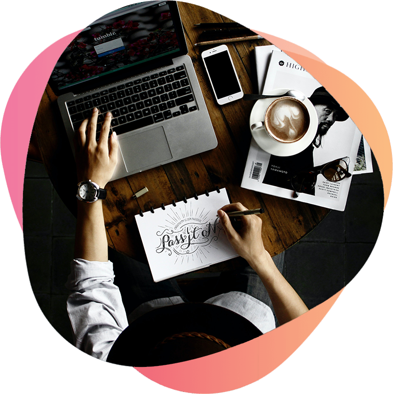Designer sketching ideas next to a laptop